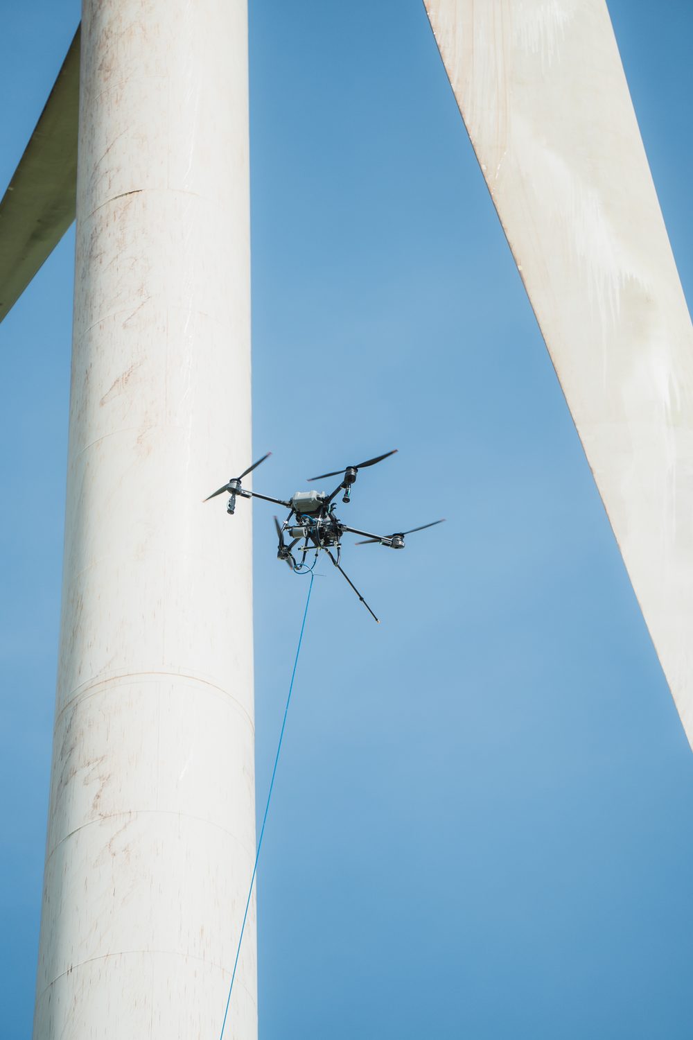 Dron de limpieza junto al fuste de la torre de un aerogenerador