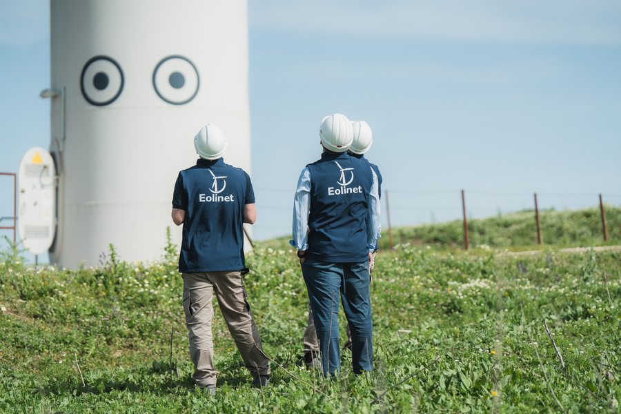 Dos técnicos de Eolinet frente a la torre de un aerogenerador