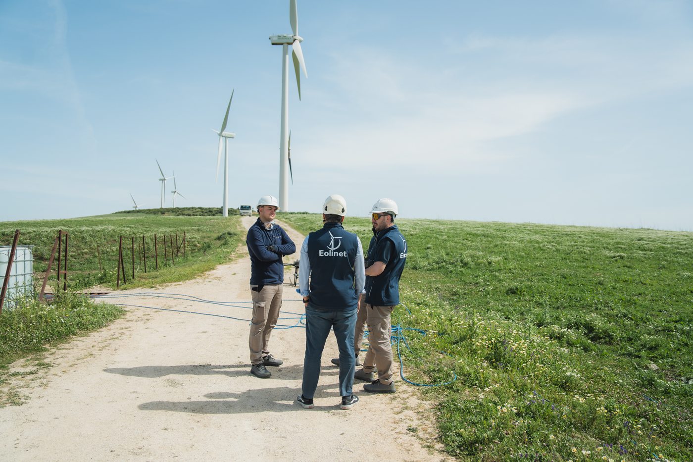 Equipo de Eolinet caminando por la pista de un parque eólico